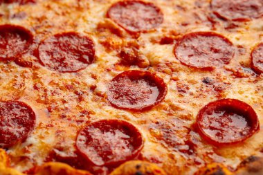 Biberli pizza ve salam soslu yakın plan.