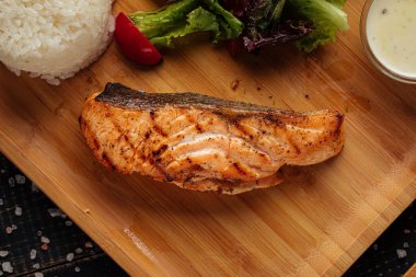 Tahtada pilavlı ızgara somon bifteği.