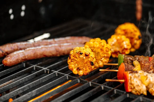 Griller des brochettes de poulet et du maïs sur un barbecue — Photo