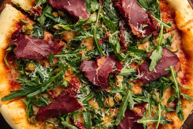 Kurutulmuş at eti ve roka ile iştah açıcı pizza.