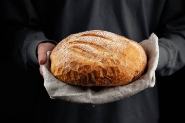 Taze pişmiş kremalı ekmeği ellerinde tutarak