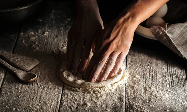Hands kneding a dough for pizza cooking with flour — Stock Photo, Image