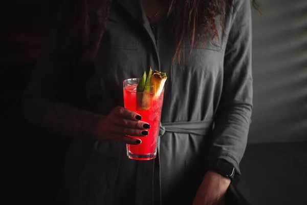 Woman holding red cocktail in a highball with ice — Stock Photo, Image