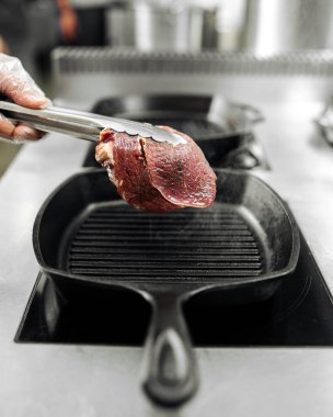 Mutfakta ızgara tavada biftek pişiriyorum.