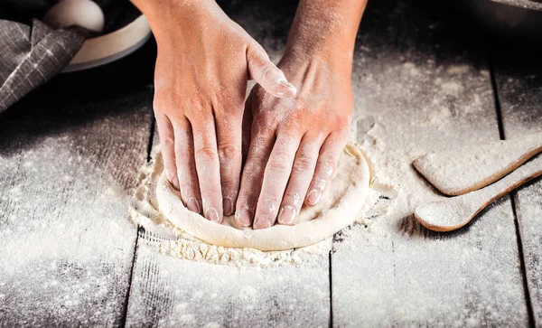 Hands kneding a dough for pizza cooking with flour — Stock Photo, Image