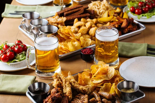 Table set with beer and salty snacks — Stock Photo, Image