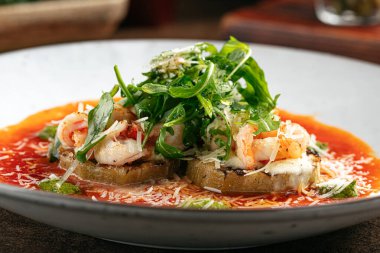 Izgara patlıcanla karides ve peynirli yakın plan.