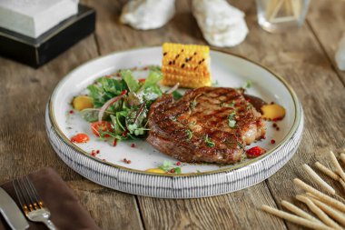 Ahşap arka planda ızgara biftek.