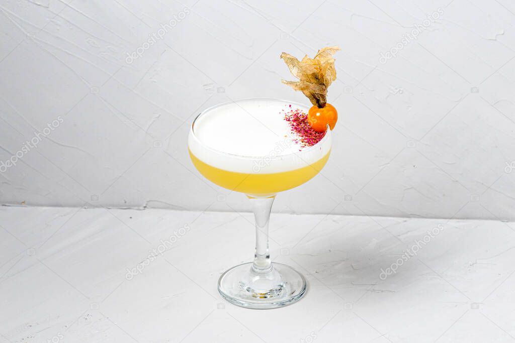 Glass of whiskey sour cocktail on white background