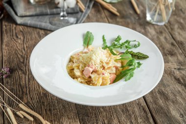 Tahta arka planda somonlu İtalyan farfalle makarnası.