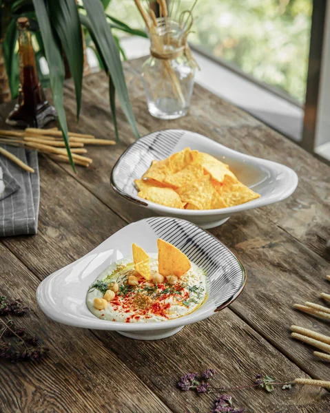 Portion Appetizers Hummus Nacho Chips Wooden Restaurant Table — Foto de Stock