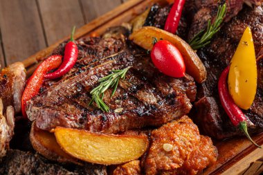 Ahşap servis tahtasındaki ızgara ete yaklaş.