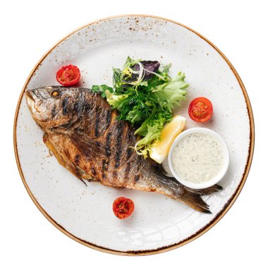 Isolated portion of grilled dorado fish with salad