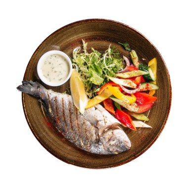 Isolated portion of grilled dorado fish with salad