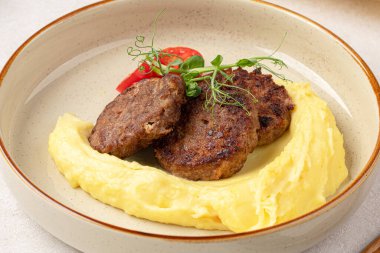 Bir porsiyon patates püresi ve otlu Rus pirzolası.