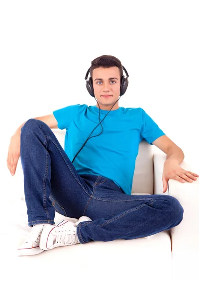 Kaunis nuori mies kuuntelee musiikkia hänen kuulokkeet — kuvapankkivalokuva