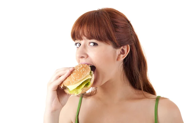 年轻有魅力的女人吃汉堡 免版税图库照片