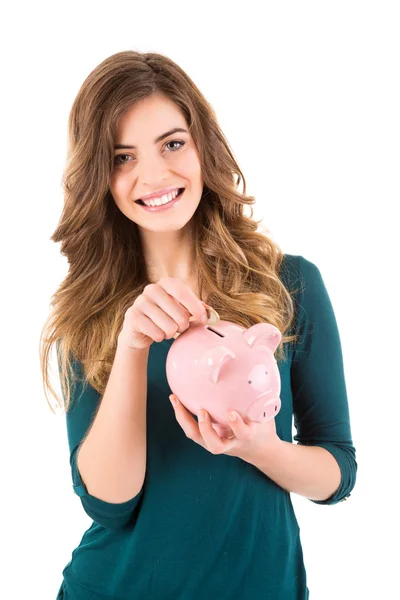 Casual vrouw op zoek naar geld besparen in een piggy bank — Stockfoto