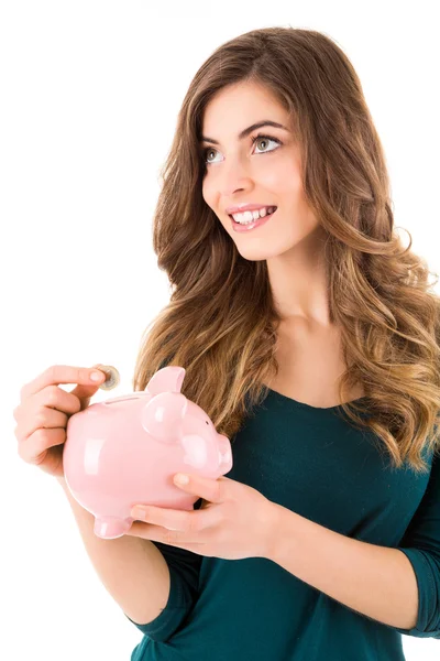 Casual vrouw op zoek naar geld besparen in een piggy bank — Stockfoto