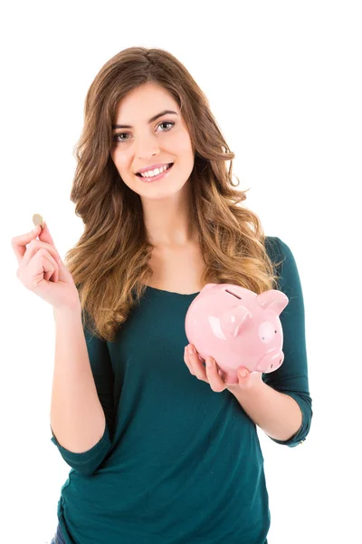 Casual vrouw op zoek naar geld besparen in een piggy bank — Stockfoto