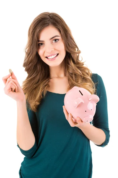 Casual vrouw op zoek naar geld besparen in een piggy bank — Stockfoto