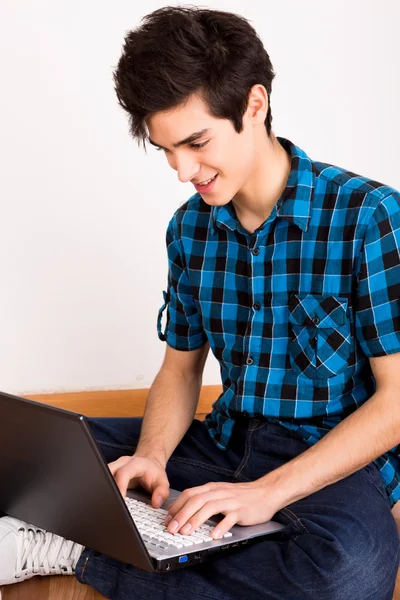 Jovem trabalhando no computador portátil em casa — Fotografia de Stock