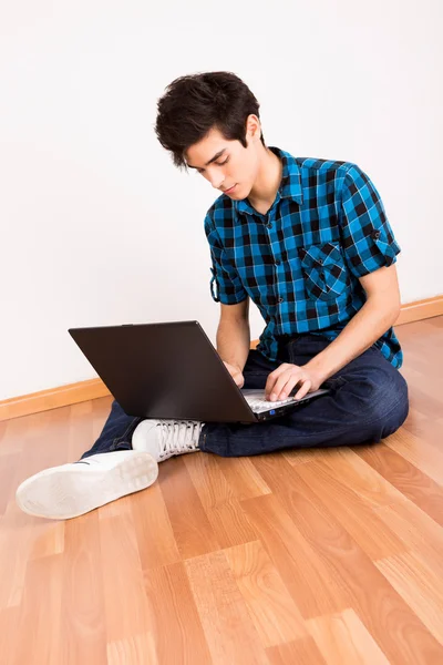 关于计算机笔记本在家里工作的年轻人 — 图库照片