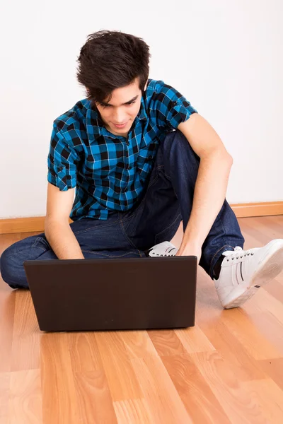 Jovem trabalhando no computador portátil em casa — Fotografia de Stock