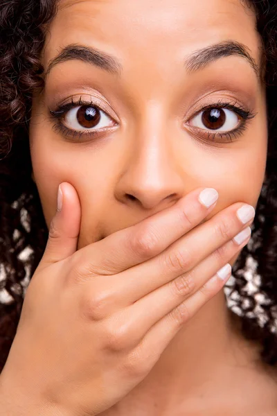 Verrast jonge Afrikaanse vrouw met handen over haar mond — Stockfoto