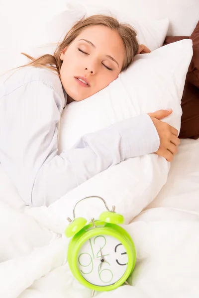 Güzel bir kadın alarmclock yatakta yatıyor — Stok fotoğraf