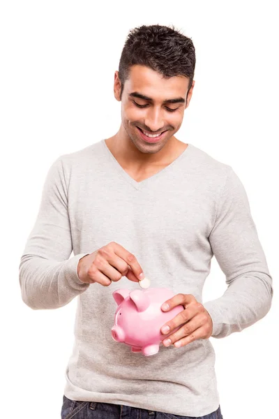 Homem economizando dinheiro para um banco porquinho — Fotografia de Stock