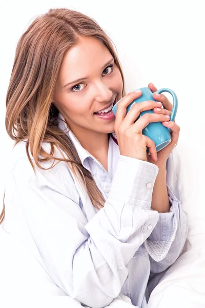 Jonge vrouw drinken in bed — Stockfoto