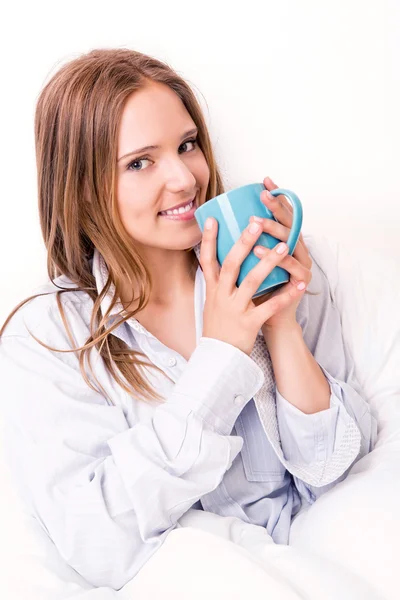 Mujer joven bebiendo en la cama —  Fotos de Stock