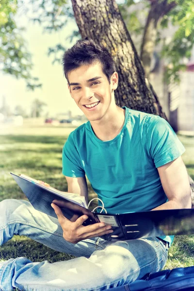 Estudiante joven estudiando en el jardín de la escuela — Foto de Stock