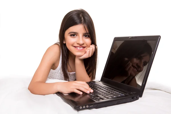 Flicka med laptop på sängen — Stockfoto
