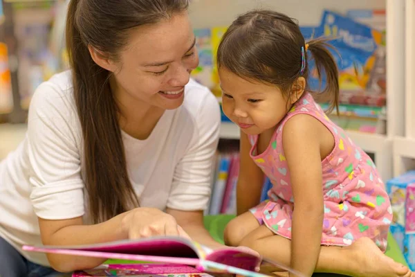 幸せな女性と子供読書本を学び 書店で教える — ストック写真