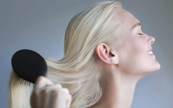 Female Modeling Her Silkly Smooth Blonde Hair While Being Brushed — Stock Photo, Image