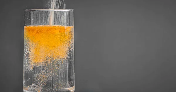 Дія Дробу Апельсинового Порошкоподібного Напою Виливається Чисту Склянку Води Ліцензійні Стокові Зображення