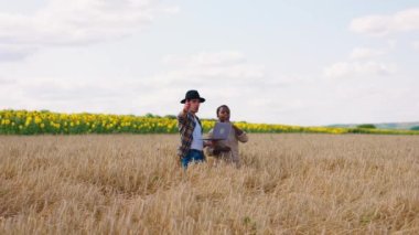Çiftçilik işi kavramı iki çiftçi Afrikalı kadın ve Avrupalı erkek buğday tarlasının ortasında hasat hakkında tartışıyorlar. ARRI Alexa Mini 'de çekilen.