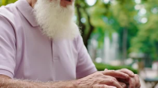 Konzentriert tippt ein gutaussehender alter Mann vor der Kamera etwas auf seinen Laptop, während er im Café sitzt. 4k — Stockvideo