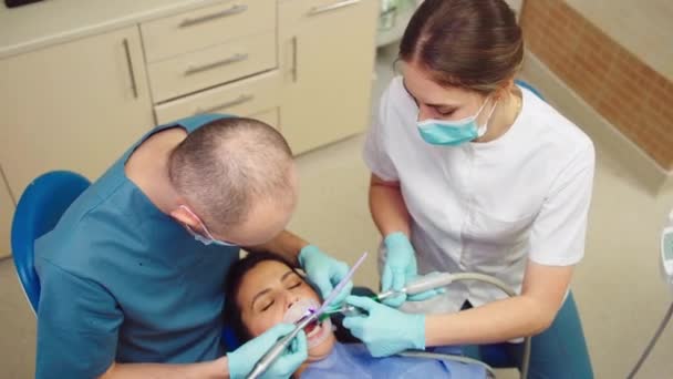 Ta video från den bästa tandläkare man göra en tänder behandling för en snygg kvinnlig patient — Stockvideo