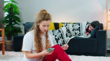 Odada yerde oturan güzel bir kadın telefonda konuşuyor, termometreyi tutuyor ve çok üzgün görünüyor çünkü kanepesinde hasta görünen bir adam var. Atış açık.