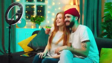 Oturma odasında kanepede mutlu, gülümseyen büyük bir çift birlikte geçirdikleri zamanın tadını çıkardıkları hafif bir yüzükle selfie çekiyorlar. ARRI Alexa 'da çekim