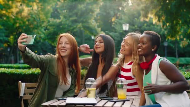 Grupo de lindas senhoras multirraciais incríveis no meio do parque no café aproveite o tempo juntos tirando algumas fotos com o smartphone — Vídeo de Stock
