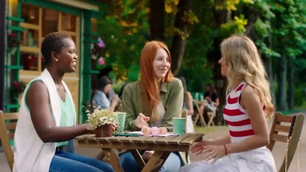 Grupo de amigos multirraciales mujeres jóvenes acelerando el buen tiempo juntos en el café tomar algunos dulces para comer y disfrutar de la conversación que están sonriendo a lo grande — Vídeos de Stock