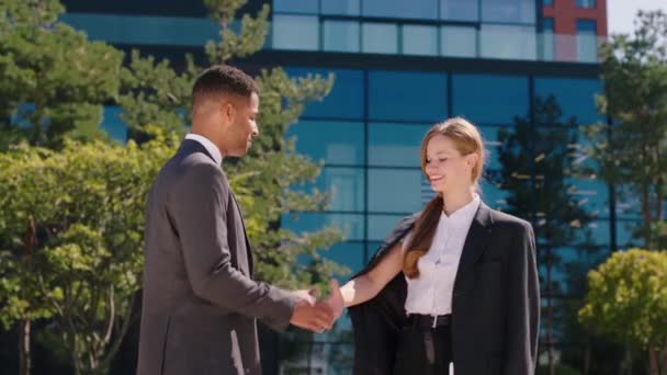 Em um dia ensolarado perfeito carismático homem negro e mulher empresários reunidos em frente ao moderno centro de negócios, eles terminam a discussão e apertam as mãos. 4k — Vídeo de Stock