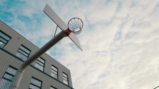 Em um estádio moderno cara alto muito carismático em um terno esporte vermelho jogando basquete e jogar o basquete na cesta — Vídeo de Stock