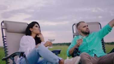 Sahanın ortasında karizmatik bir adam ve güzel karısı şampanya içerken ve sandalyelerde otururken birlikte rüya görüyorlar.