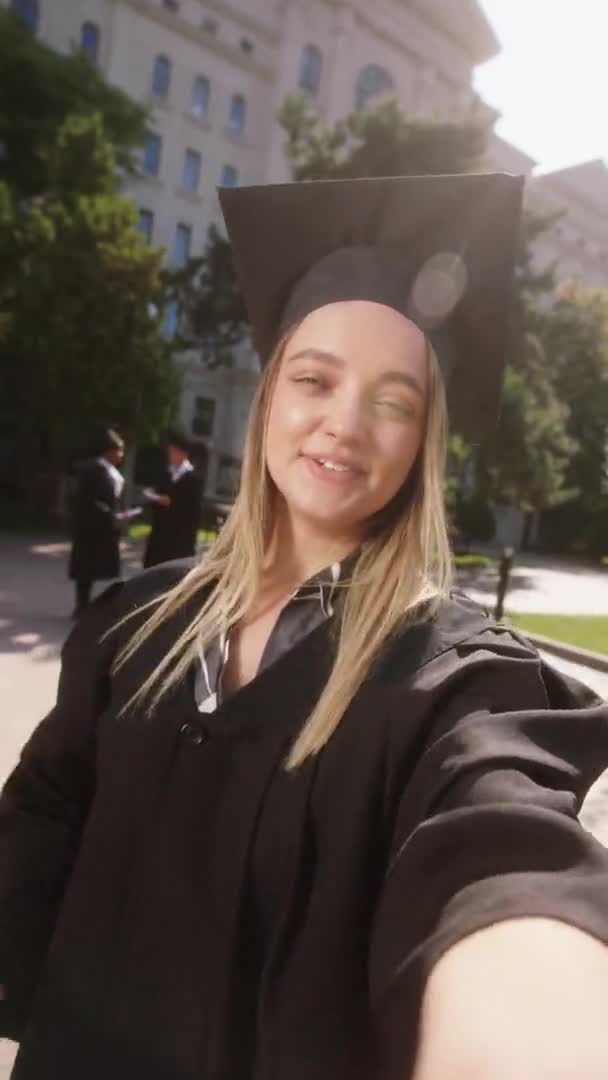 Buiten het universiteitsgebouw in de tuin maakt een charismatische dame een selfie video voor haar ouders nadat ze afgestudeerd is. Neergeschoten op ARRI Alexa Mini. — Stockvideo