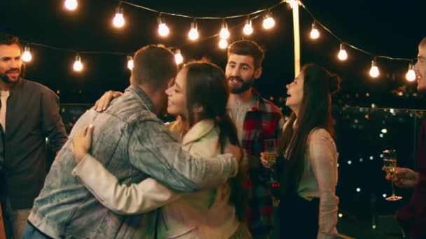 На вечеринке на крыше террасы удивительная компания друзей наслаждается ночными танцами и чувствует себя удивительно — стоковое видео